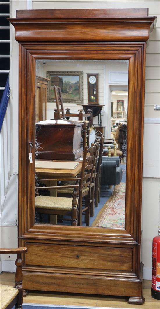 A Charles X mahogany wardrobe, with moulded cornice, fitted mirror panelled door and base drawer, on ogee feet, W.106cm